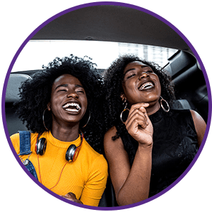 two-young-women-laughing-in-backseats-of-car